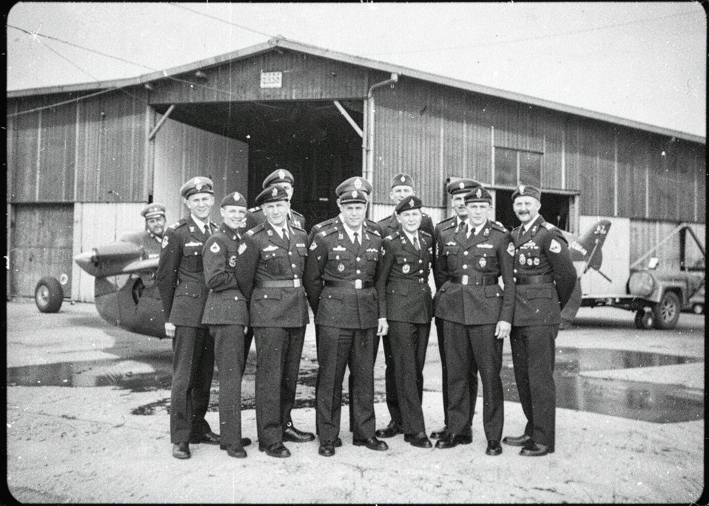 Archival black and white photograph of air cadets in front of a hangar